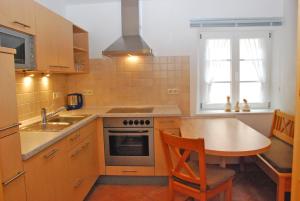 a kitchen with a table and a stove and a sink at Ferienhaus Becker in Schönau +5 photos