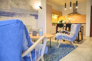 salon z niebieskimi krzesłami i stołem w obiekcie Apartamenty Na Wyspie - Baltic Park - Apartamenty z sypialnią i parkingiem - ul Uzdrowiskowa 24-34 w Świnoujściu