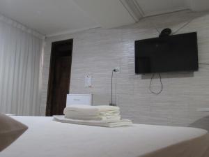 un montón de toallas sentadas en una cama con TV de pantalla plana en River Class Hotel, en Petrolina 32 fotos más