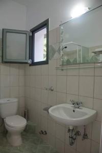 a bathroom with a sink and a toilet and a mirror at Miloni Studios in Lourdhata