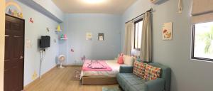 a small room with a bed and a couch at Summerle No.11 in Chaozhou