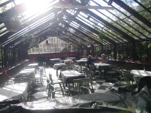 a restaurant with tables and chairs in a greenhouse at Ormidale Hotel in Brodick