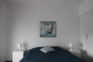 ポンタ・デルガダにあるCasa da Pracetaのベッドルーム1室(青いベッド1台、ランプ2つ付)