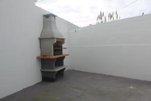 uma pequena lareira ao lado de uma parede branca em Casa da Praceta em Ponta Delgada