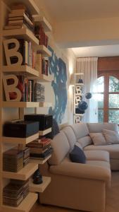 a living room with a couch and a book shelf with books at Villa I Tamarigi in Maruggio