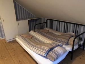 a bed with striped pillows on it in a room at 103 Hvilestedvej in Fredericia