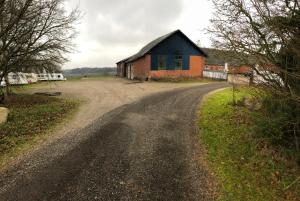 a dirt road in front of a barn at 103 Hvilestedvej in Fredericia