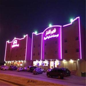 a large building with purple lights on it at night at Al Fanar Palace 1 in Riyadh