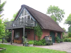 een klein rood bakstenen huis met een terras erop bij Nordsee-Paradies in Barlt