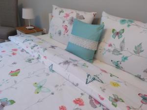 a bed with butterflies bed sheets and pillows at Apartament Poniatowskiego in Radom