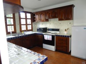 een keuken met houten kasten en een witte kookplaat bij Bella Casa en Antigua Guatemala in Antigua Guatemala
