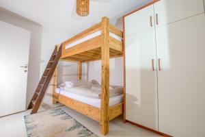 a bunk bed in a room with a ladder at SunsetLoft Vir in Vir