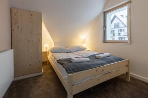 una camera da letto con un grande letto e una finestra di Dom Pod Jesionem Zakopane a Zakopane