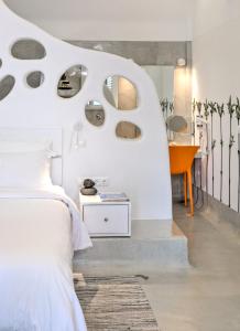 a bedroom with a white bed and a table at Kouros Village Hotel - Adults Only in Perissa