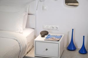 a bedroom with a bed and two blue vases at Kouros Village Hotel - Adults Only in Perissa