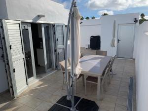 a patio with a table and an umbrella at Villa Malagueñas in Puerto del Carmen