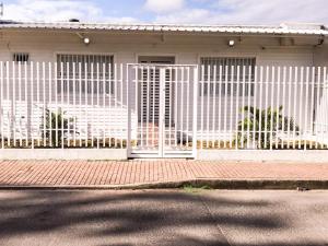 a white fence in front of a house at Tropical Breeze Aeropuerto in San Andrés