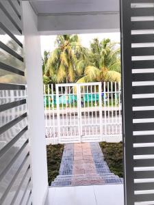 uma cerca branca com palmeiras ao fundo em Tropical Breeze Aeropuerto em San Andrés