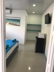 a small room with a bed and a television in it at Tropical Breeze Aeropuerto in San Andrés