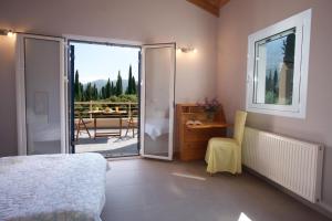 a bedroom with a bed and a view of a patio at Anatoli Villa in Agia Effimia