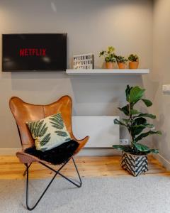 une chaise avec un oreiller dans une chambre avec une plante dans l'établissement Janika's Patio, à Porto