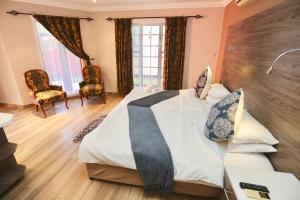a bedroom with a large bed and two chairs at Minen Hotel in Tsumeb