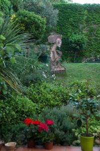 une statue d'une femme tenant un parasol dans un jardin dans l'établissement CHAMBRE SPACIEUSE DANS MAISON ART DECO au CENTRE DE TOULOUSE, à Toulouse