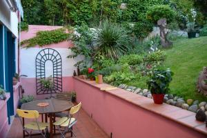een patio met een tafel en stoelen en een tuin bij CHAMBRE SPACIEUSE DANS MAISON ART DECO au CENTRE DE TOULOUSE in Toulouse