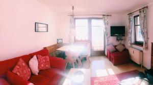 a living room with a red couch and a table at Dachstein view ski apartment in Gosau