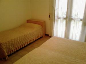 mały pokój z 2 łóżkami i oknem w obiekcie Villa Flamicia 1P w Lignano Sabbiadoro