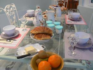 una mesa de cristal con comida encima. en gîte de la maison de l'étang en Sampigny