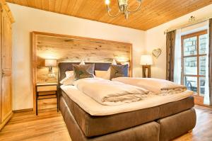 a bedroom with a large bed with a wooden wall at Wohlfühl-Ferienwohnungen Kirchberger in Bodenmais