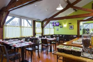 a restaurant with tables and chairs in a room at Sky Hotel Goussainville Charles de Gaulle in Goussainville
