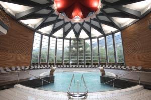 ein Schwimmbad in einem Gebäude mit einem großen Fenster in der Unterkunft Hôtel d'Etigny in Luchon