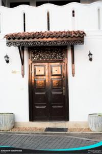 una puerta de madera con techo de baldosa en una casa en Seagreen Guesthouse, en Galle