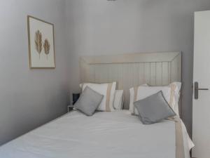a bed with white sheets and pillows in a bedroom at Casa La Alameda,Valle Gran Rey, La Gomera in Valle Gran Rey