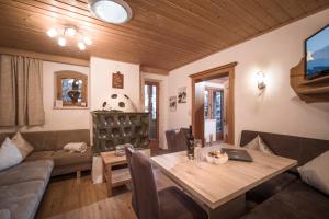 a living room with a table and a couch at Landhaus Alpbach in Alpbach