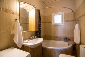 a bathroom with a sink and a tub and a toilet at St George's Castle House in Peratáta +37 photos