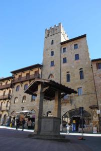 um grande edifício de pedra com uma fonte em frente em La Corte Del Re em Arezzo