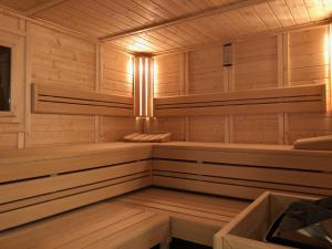 a sauna with wooden paneling and benches and lights at FeWo Bettenhausen in Morschen +1 photo