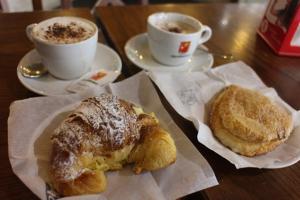 dos tazas de café y dos pasteles en una mesa en Affittacamere Casa Corsi, en Florencia