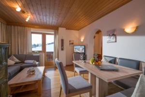 a living room with a table and a couch at Landhaus Alpbach in Alpbach