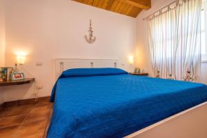 a large blue bed in a white bedroom at Casa del Sale, a 50 m dalla spiaggia in Lascari