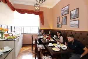 a group of people sitting at tables in a restaurant at TERRA PREMIUM Hostal Boutique in Quito