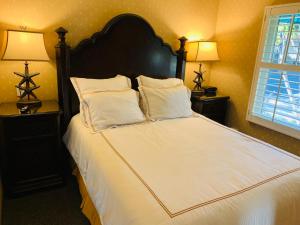 a bed with two pillows and a night stand at Franciscan Inn & Suites in Santa Barbara