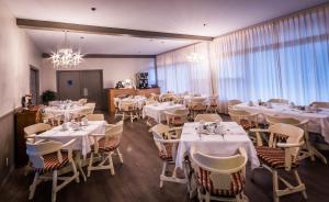 Hotel La Caravelle في بيه كومو: مطعم بطاولات بيضاء وكراسي وثريا
