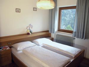 - une chambre avec 2 lits et une fenêtre dans l'établissement Apartments Ruac, à La Valle