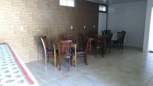 a group of chairs and tables in a room with a brick wall at Pousada dos Ventos in Penha