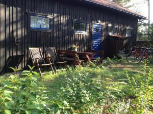 uma mesa de piquenique e cadeiras fora de uma cabana em Brissund em Visby