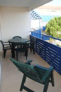 un balcón con hamaca, mesas y sillas en Agréable T2 balcon et piscine dans résidence bord de mer en Lacanau-Océan